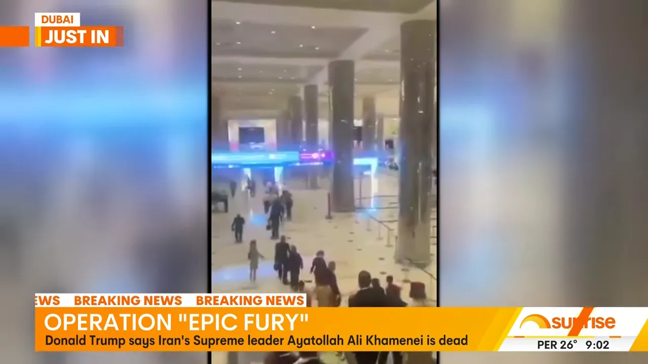 Passengers evacuating a Dubai airport terminal amid breaking news coverage