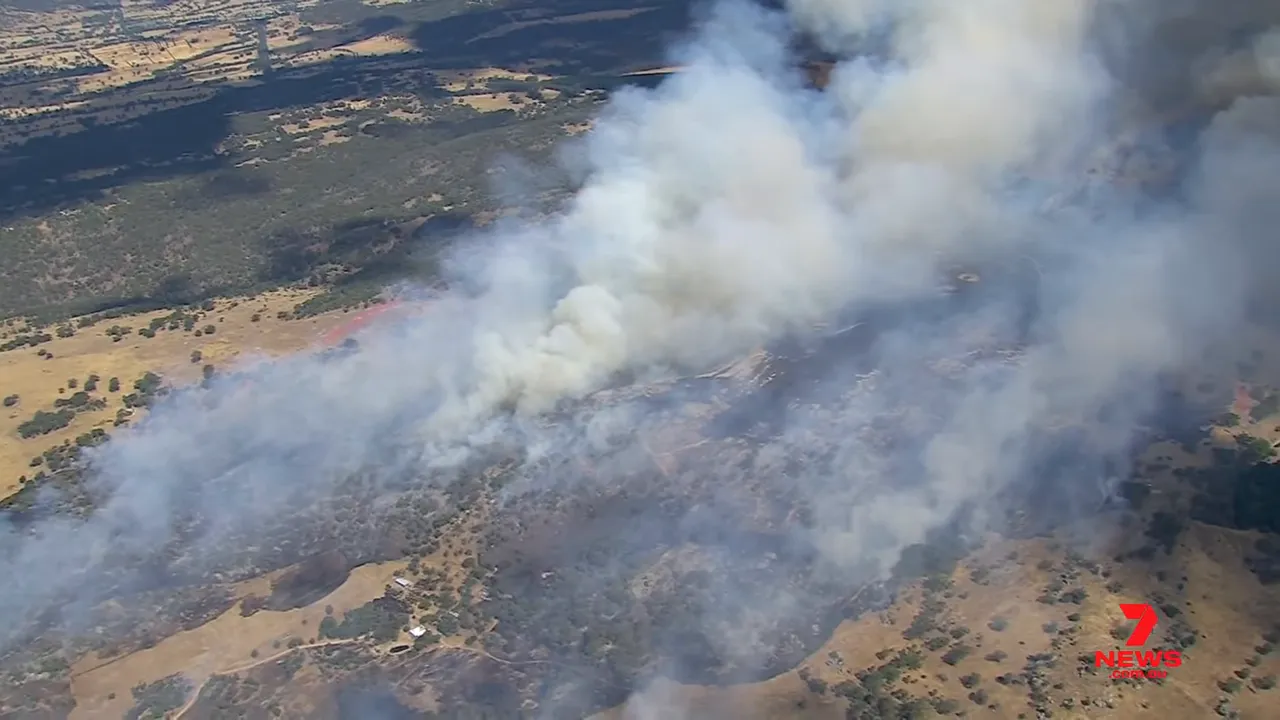 Aerial image of advancing bushfire smoke and scorched paddocks near a rural property