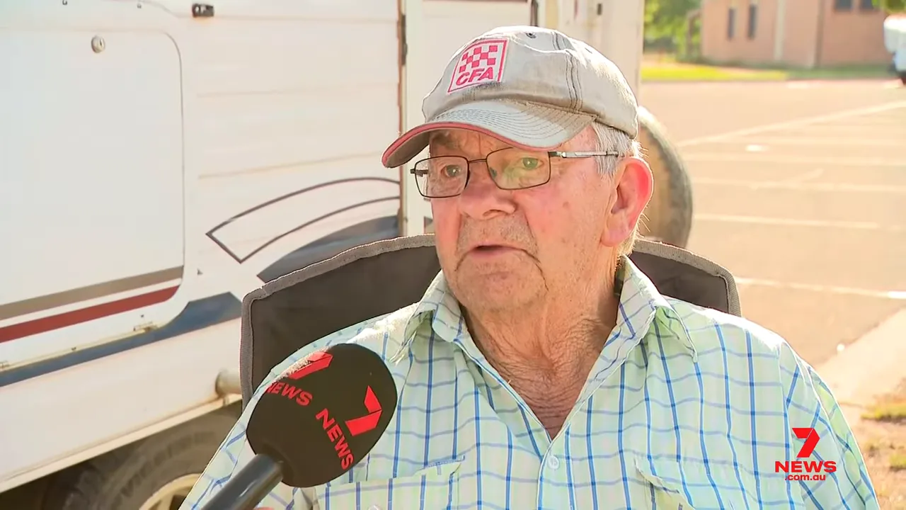Clear, well-framed image of an elderly farmer in a cap being interviewed outdoors with a Seven News microphone visible.