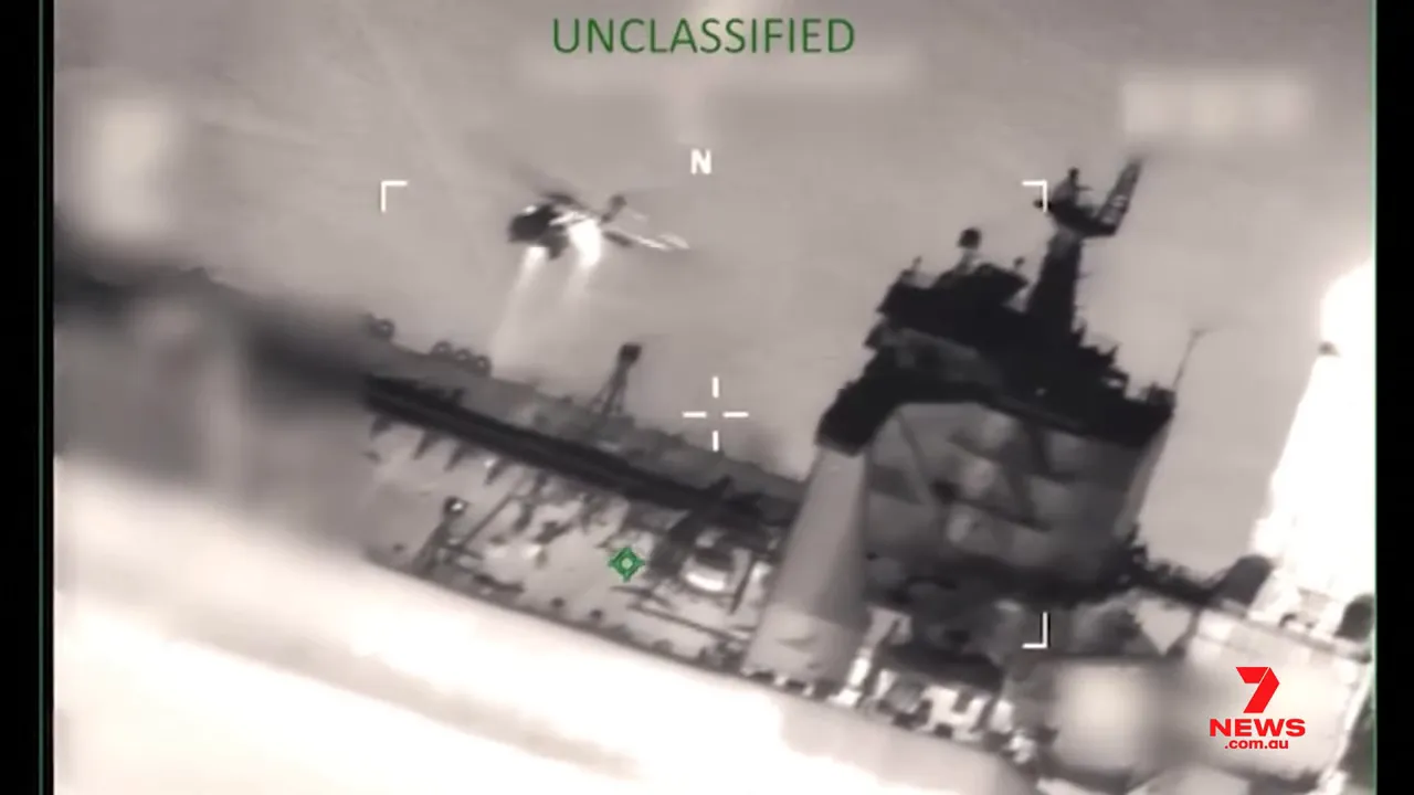 aerial infrared image of a helicopter approaching an oil tanker during a Coast Guard boarding