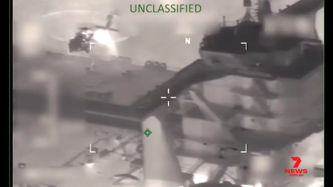 Thermal night-vision view showing a helicopter and deck during a Coast Guard boarding operation of an oil tanker, with ‘UNCLASSIFIED’ label and 7NEWS watermark.