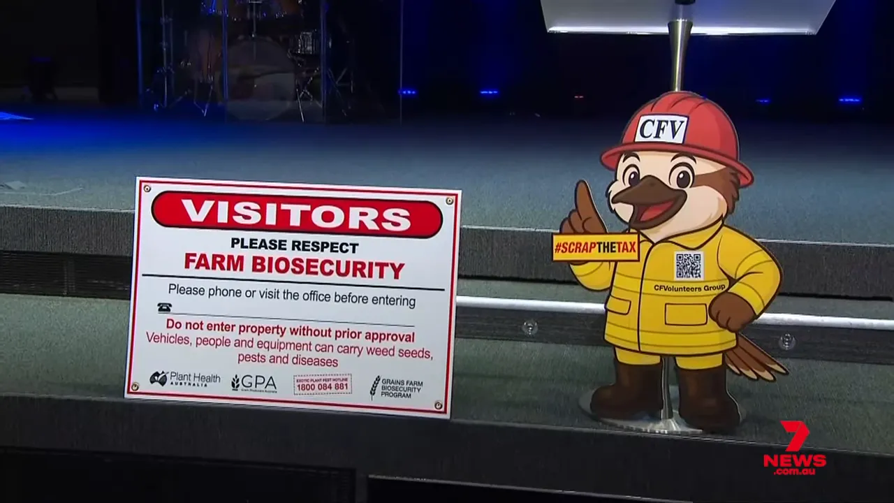 Farm biosecurity visitors sign displayed next to a CFV volunteer mascot holding a '#SCRAPTHETAX' placard on a stage.