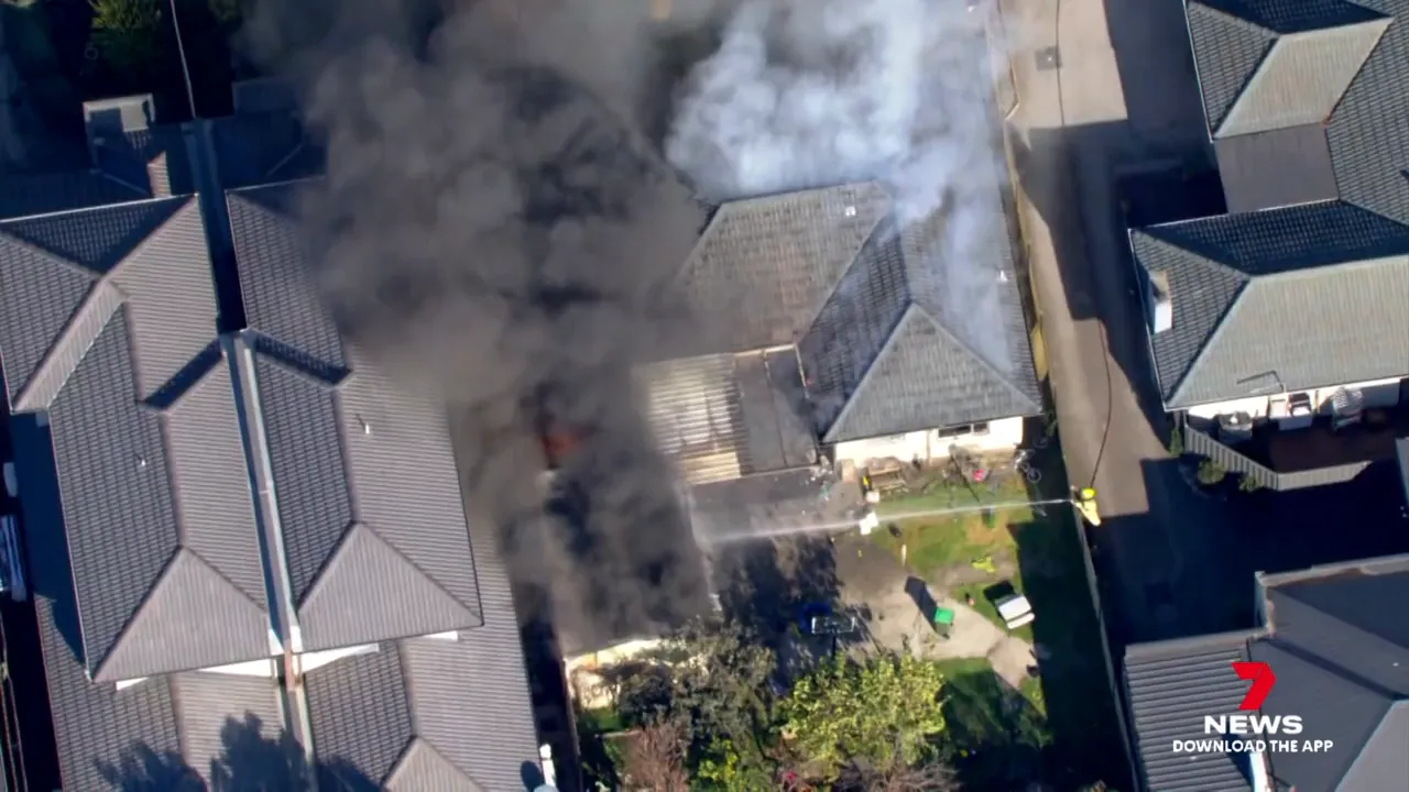 Black and gray smoke rising from Altona North house and backyard shed burning
