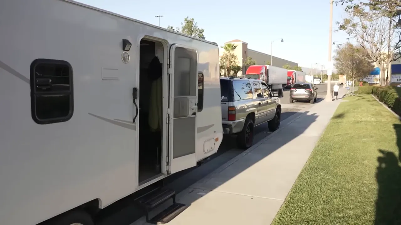 Roy standing beside his caravan, the interior visible through the door