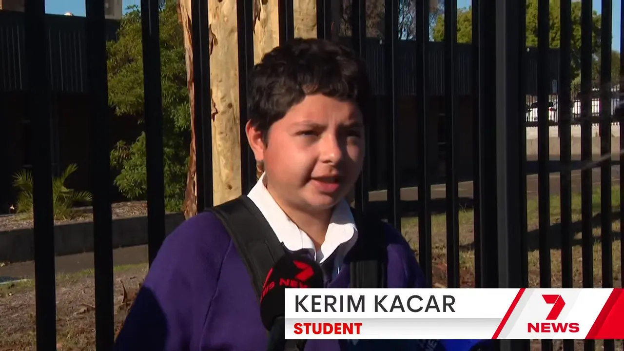 Student being interviewed outside a school fence describing the lockdown