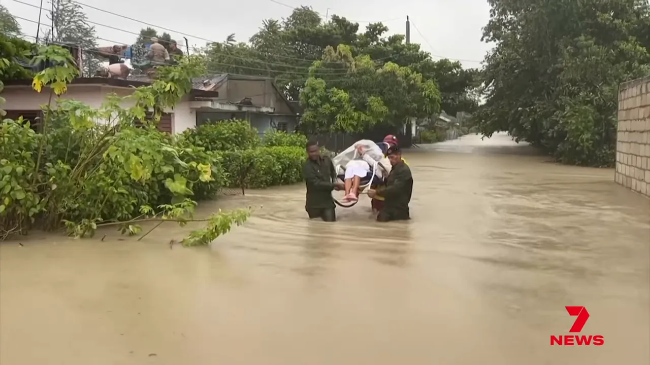 Military personnel rescuing residents from floodwaters in Cuba