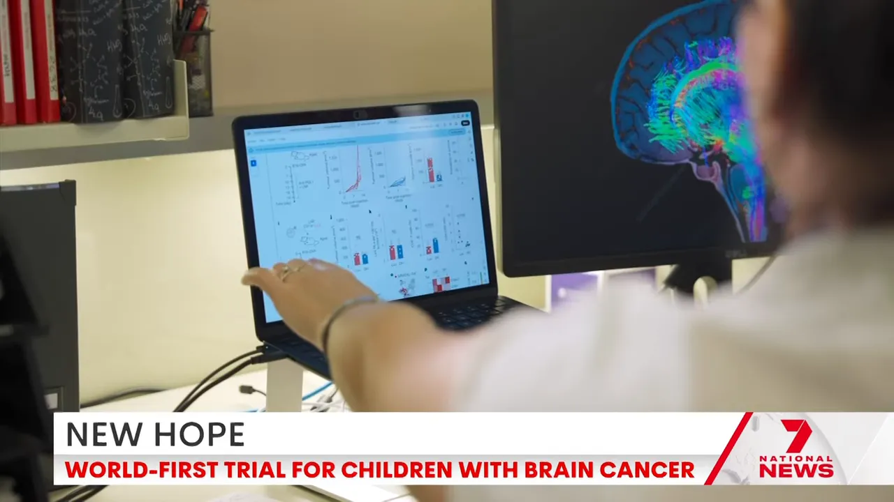 Laptop screen showing sequencing charts next to a monitor with colourful brain imaging used for personalised vaccine design