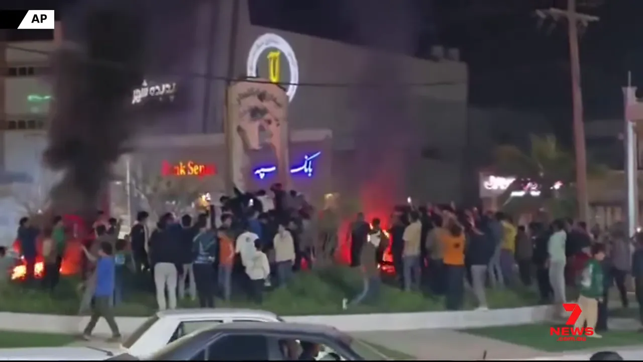 Night-time street crowd cheering with smoke and small fires