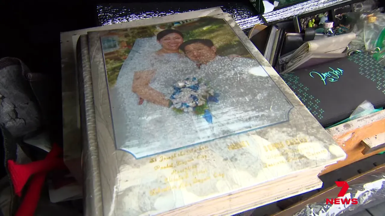 Close-up of a wedding photo album with water damage and soot among salvaged items.