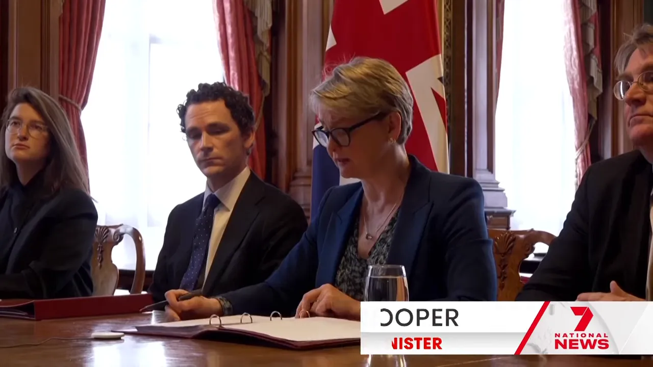 Penny Wong seated at a ministerial meeting table with other officials and banner about Trump warning Iran to make a deal
