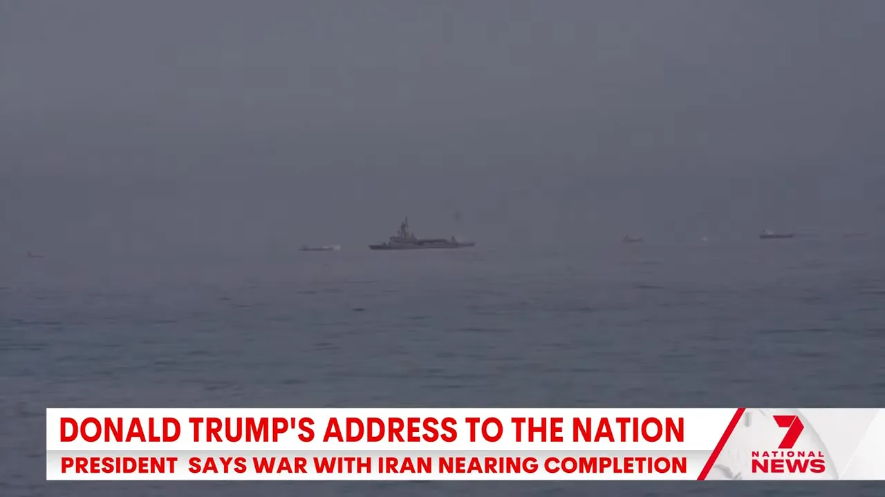 Naval ships on the water during news coverage about escalation risks near the Strait of Hormuz