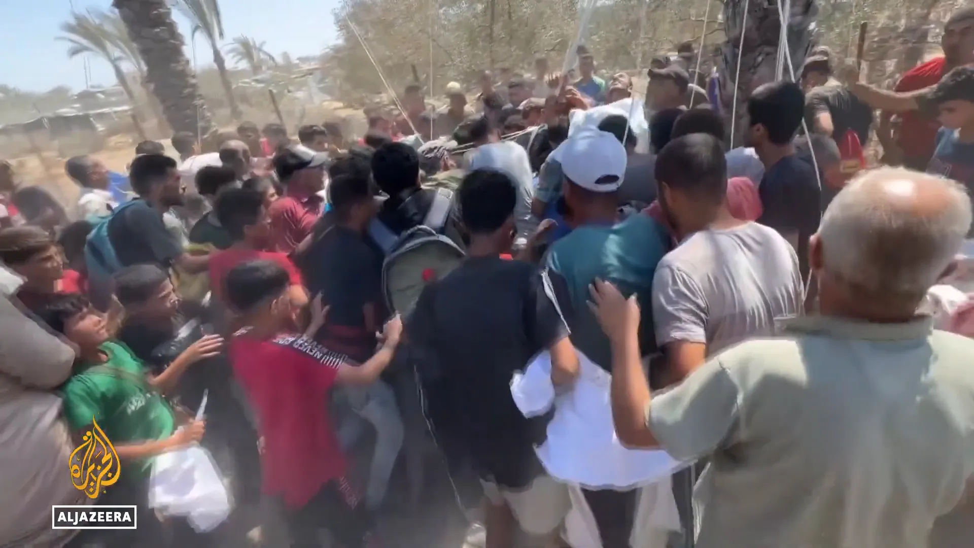 People sprinting to collect airdropped aid in Gaza