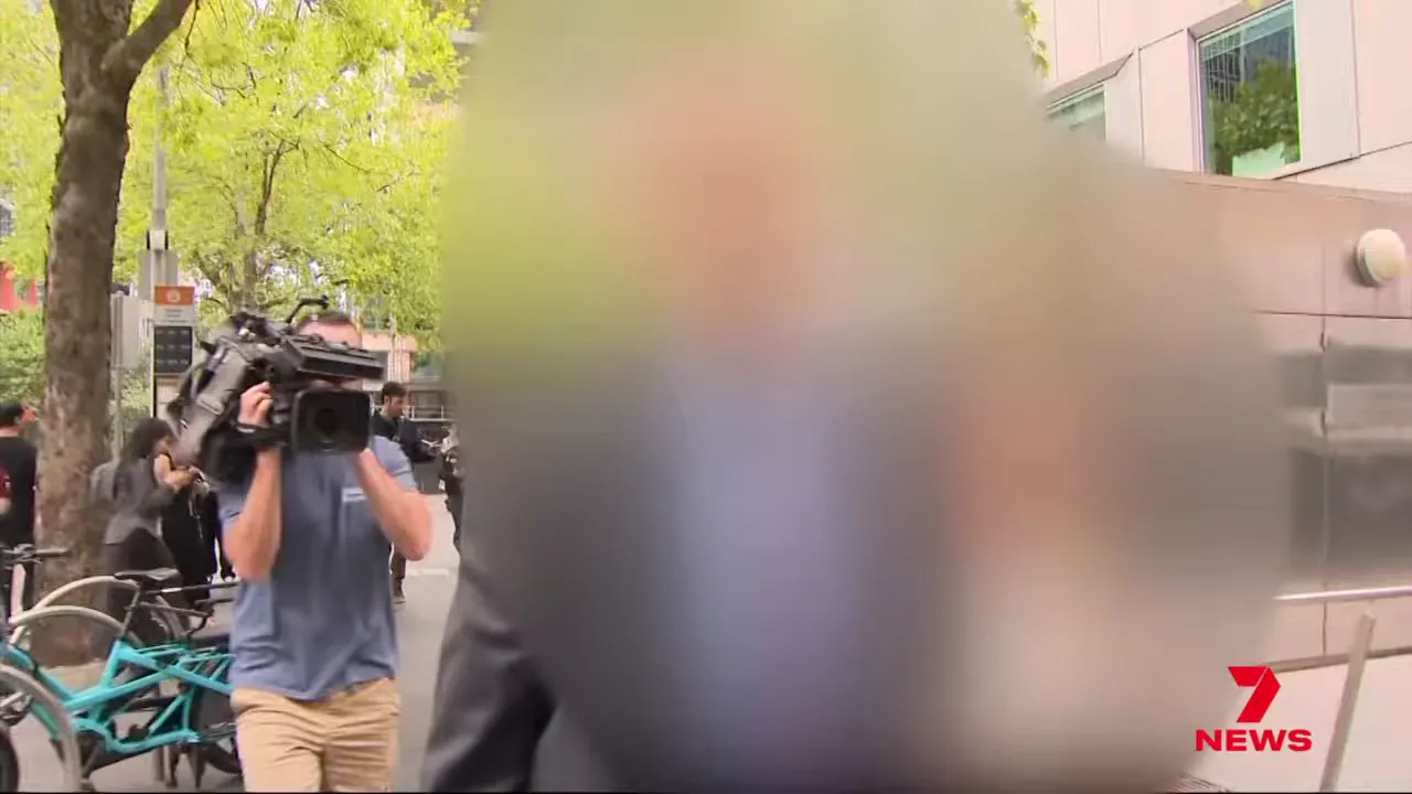 Camera operator filming as blurred figures are escorted past the County Court entrance