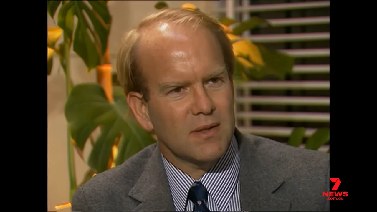 male expert in a suit speaking in a studio interview about media influence