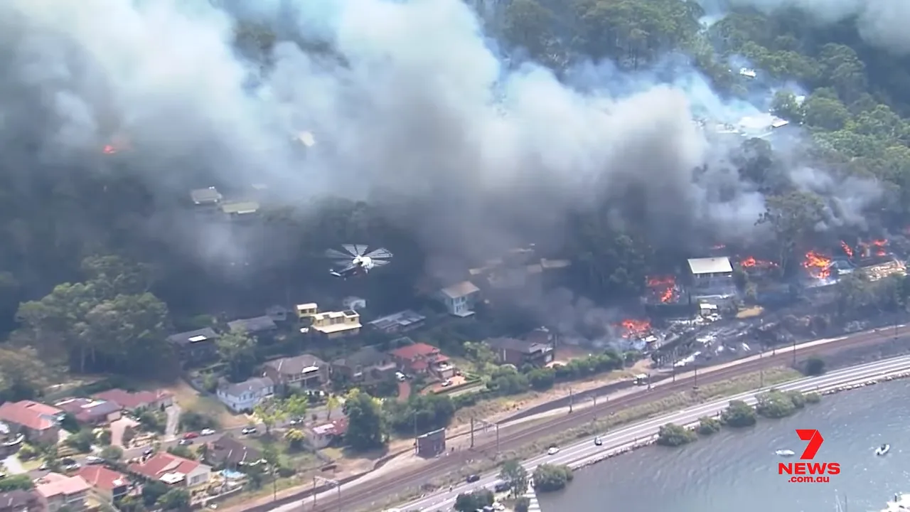 A helicopter operating above a smoke-filled residential area during the Koolewong bushfire.