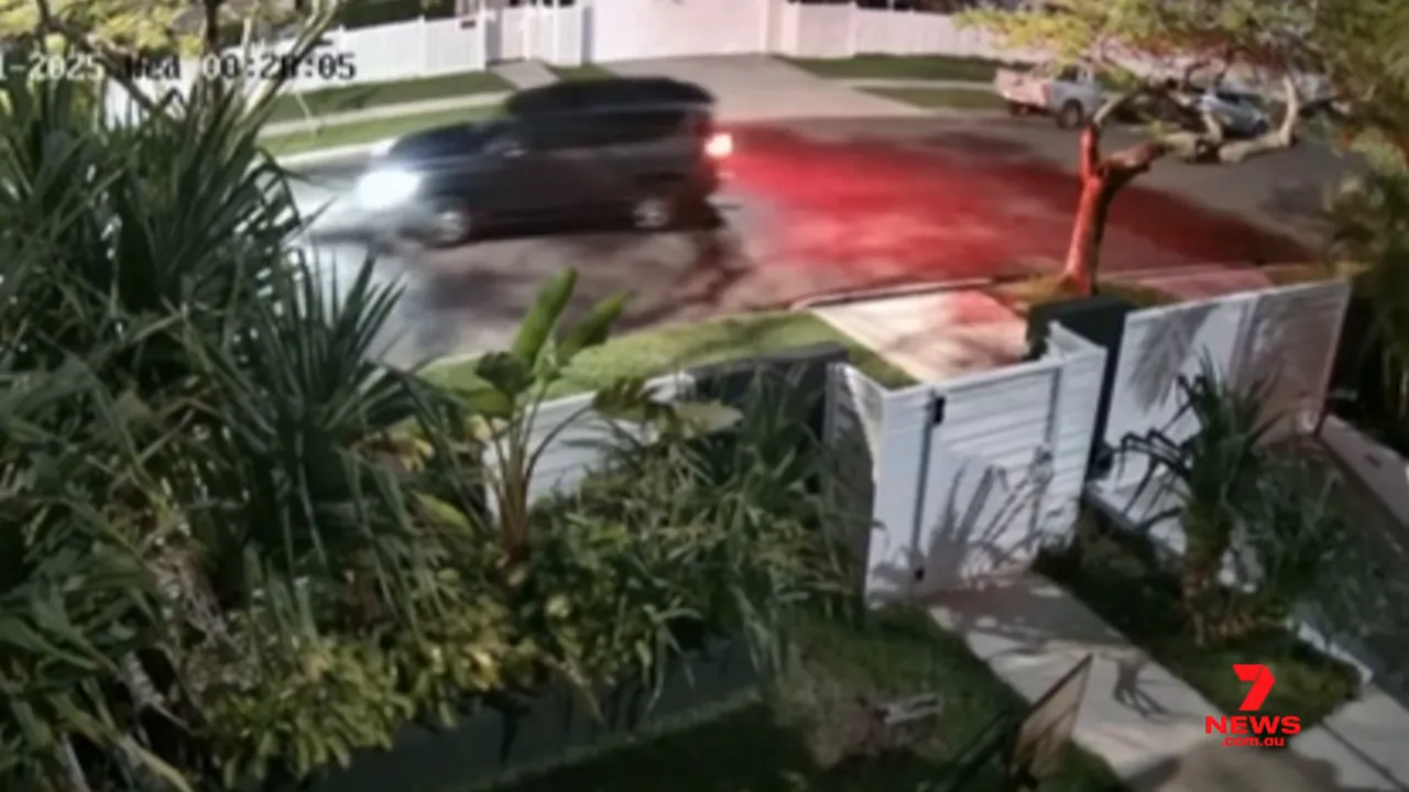 Night CCTV still of an SUV passing a residential property showing taillights and vehicle outline