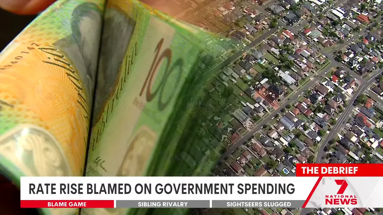 Australian banknotes and aerial view of suburban housing with headline 'Rate rise blamed on government spending'.
