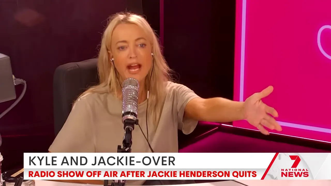 Radio host reaching out and speaking into a microphone in a pink-lit studio, mid-gesture.