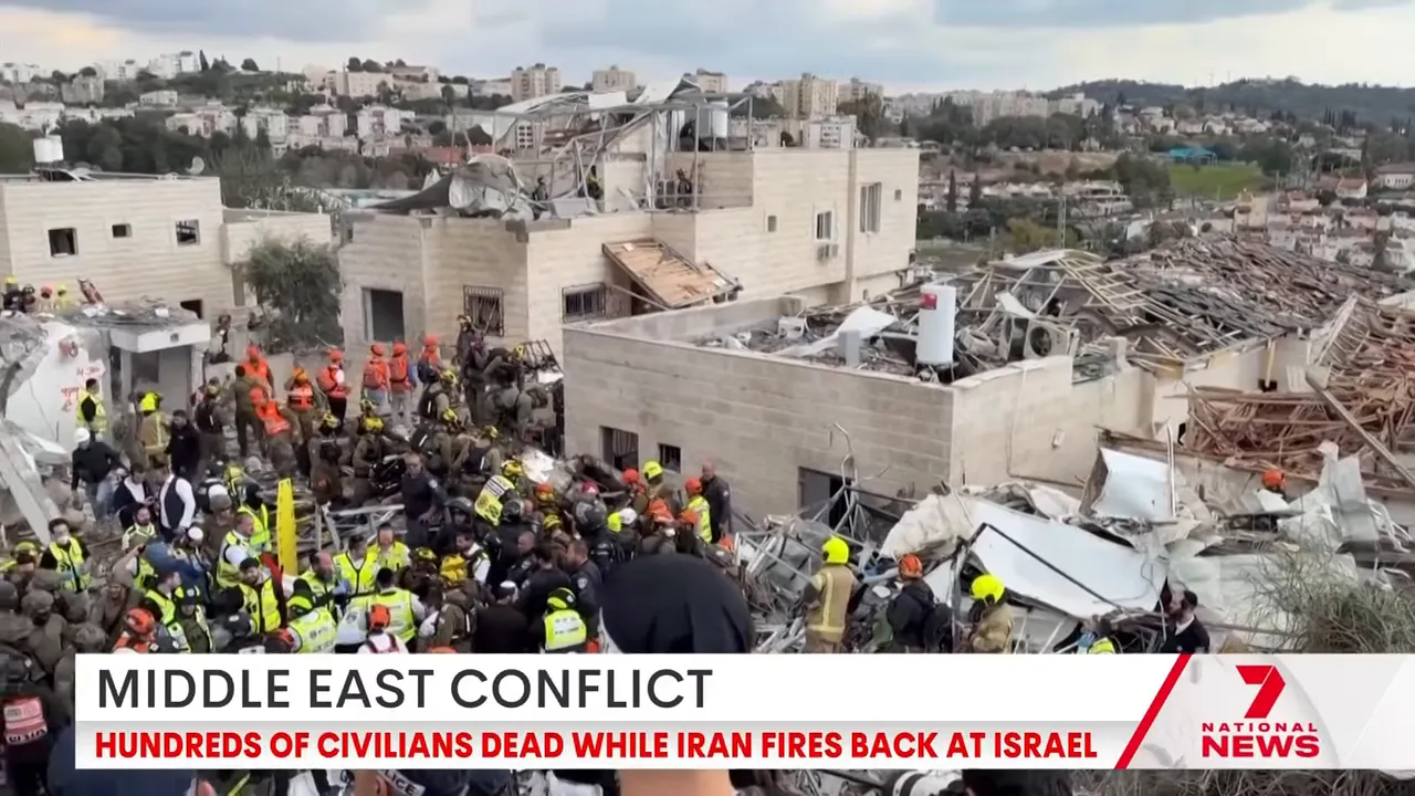 Wide view of damaged residential buildings and many emergency workers searching through rubble.