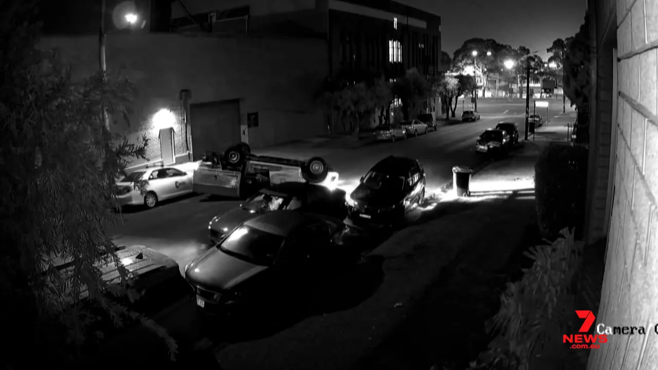 Clear CCTV image of an overturned utility on its roof after a collision on Benaroon Road, Belmore.