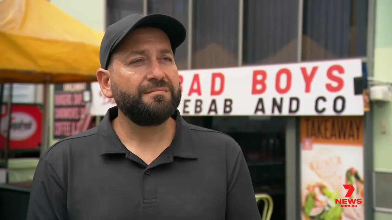 Shop owner being interviewed outside 'Bad Boys Kebab and Co' near the Benaroon Road crash site in Belmore.
