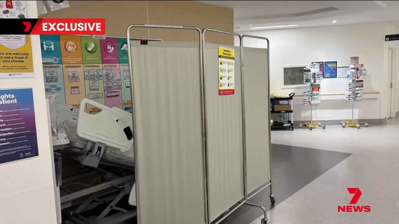 Foldable privacy screens around a hospital bed in a ward area, illustrating a makeshift patient space.