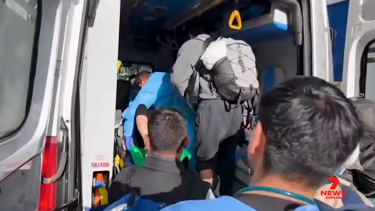 Paramedics loading injured passenger into ambulance after Machu Picchu train collision