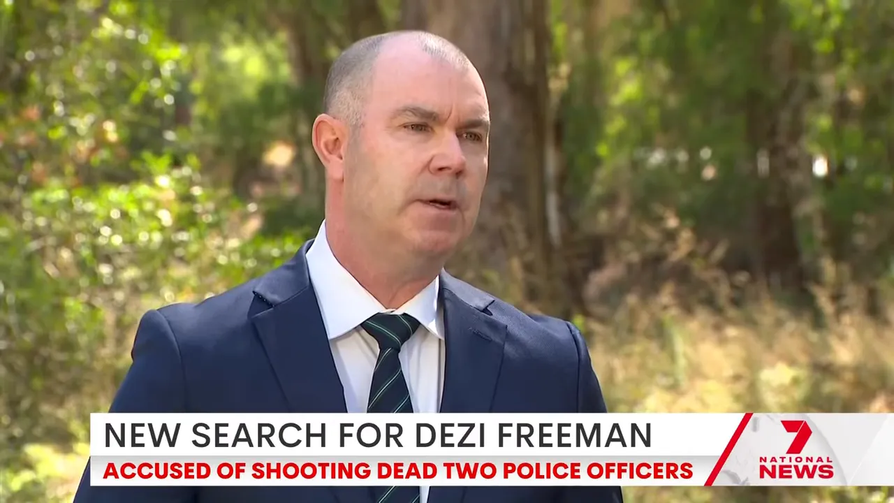 Senior Victoria Police officer speaking at an outdoor media briefing in bushland.