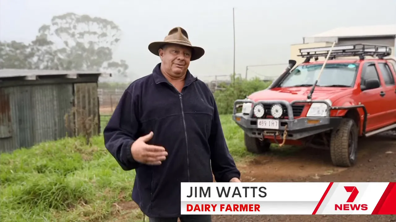 Dairy farmer Jim Watts on camera outdoors near a red vehicle