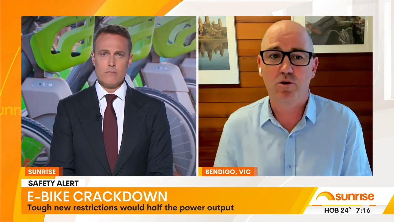 Split-screen news interview showing studio anchor and expert with bike docks visible