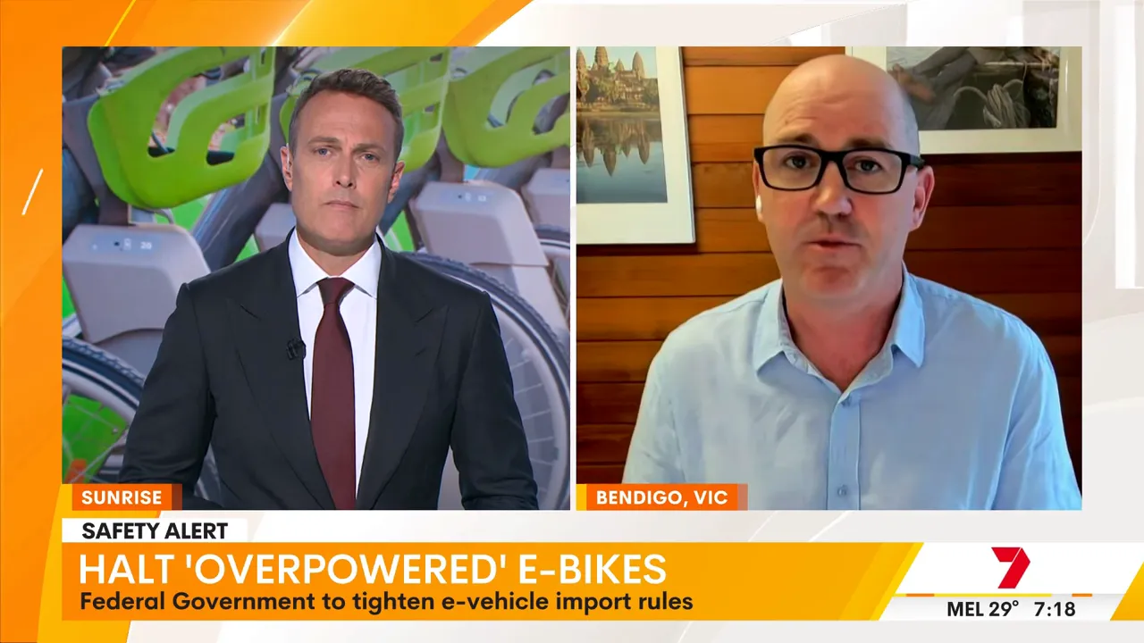 Split-screen TV interview: a studio presenter with bike imagery on the left and a remote expert on the right discussing e-bike rules.
