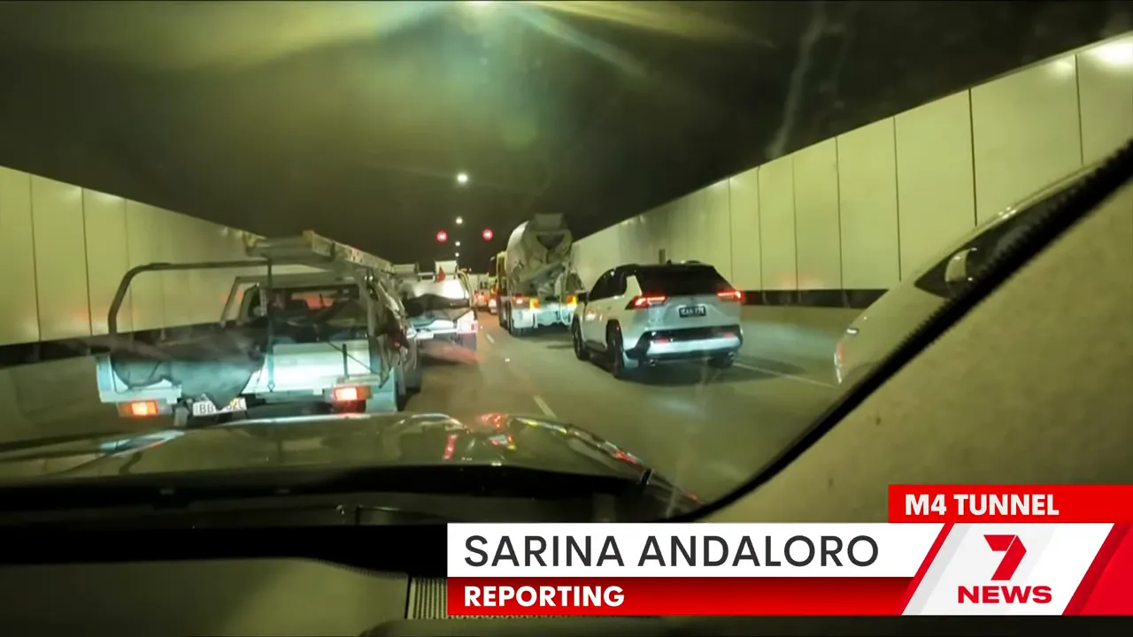 Inside the M4 tunnel showing stationary cars, a cement truck and heavy congestion seen from a dashboard view