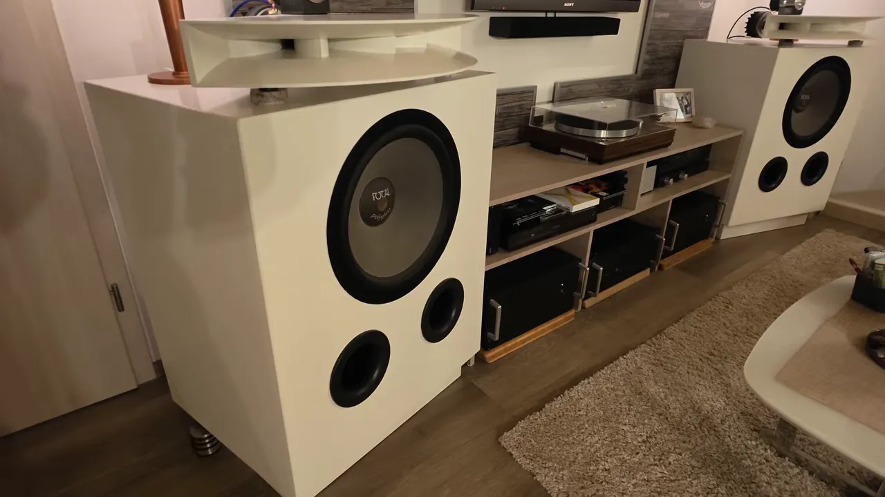 Zwei große weiße Selbstbau-Lautsprecher mit großen Basschassis und aufgesetzten Hörnern neben einem HiFi-Regal mit Plattenspieler
