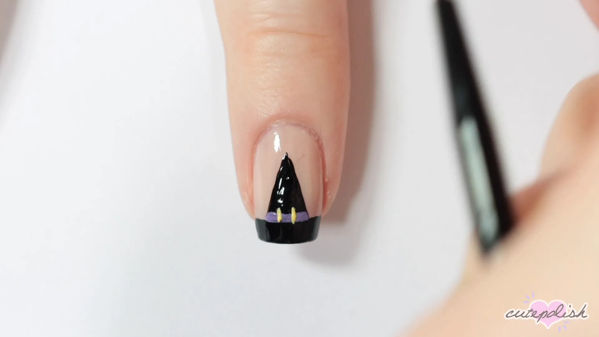 Spooktacular Nail Art: 10 Easy Halloween Designs 16 Completing the witch hat design with a buckle.