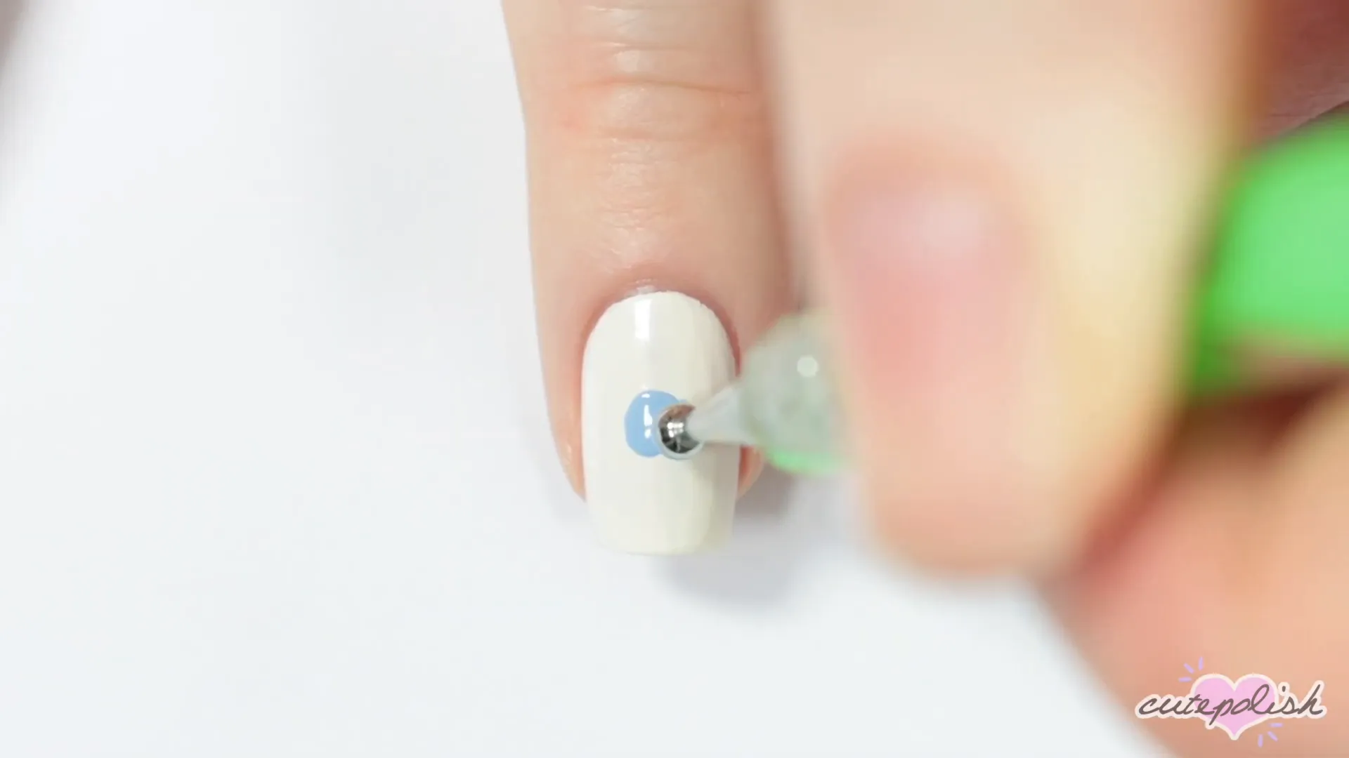 Spooktacular Nail Art: 10 Easy Halloween Designs 2 Starting the spooky eyeball design with a white base and blue dot.