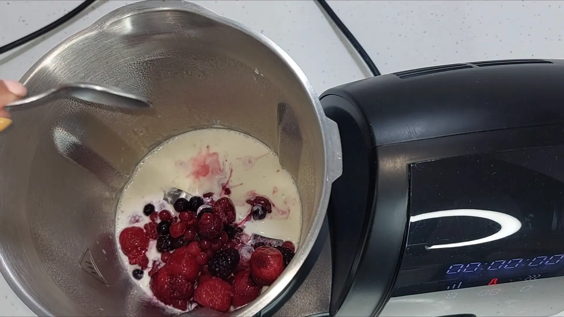 Mezclando frutos del bosque con la nata y el queso