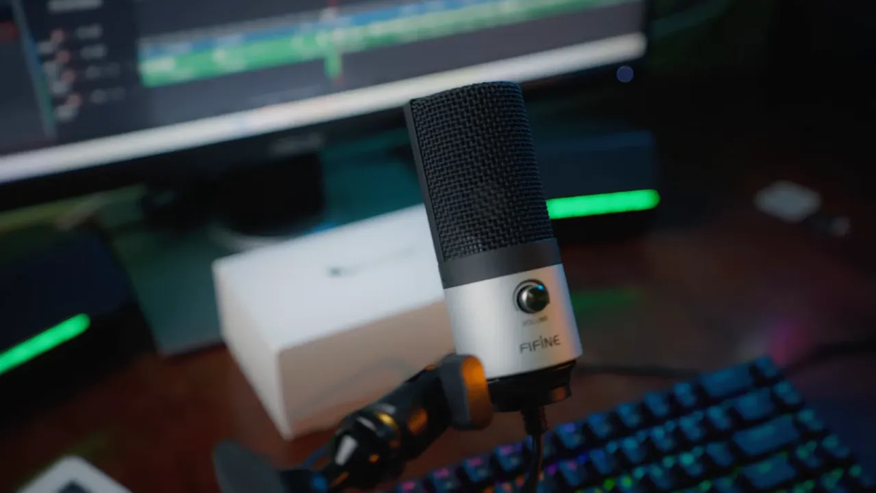 Microphone FIFINE K669S fixé à un bras articulé devant un clavier et un écran