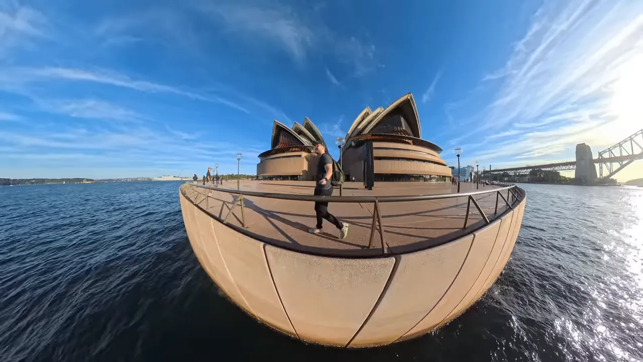 360 waterfront image with the Opera House and a person walking along the promenade, showing motion and wide dynamic range.