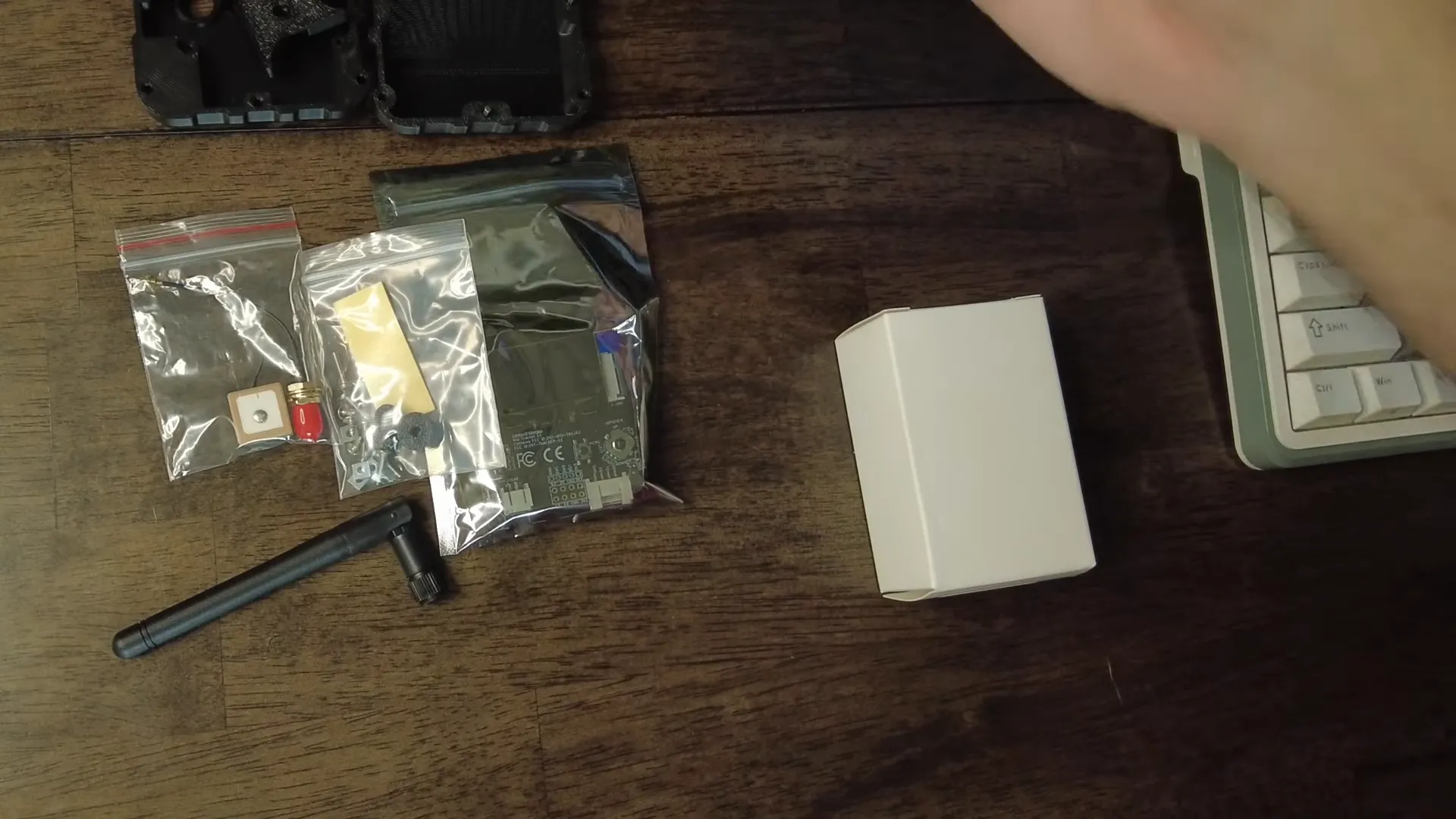 Parts laid out: board, GPS puck, antenna, buttons, battery