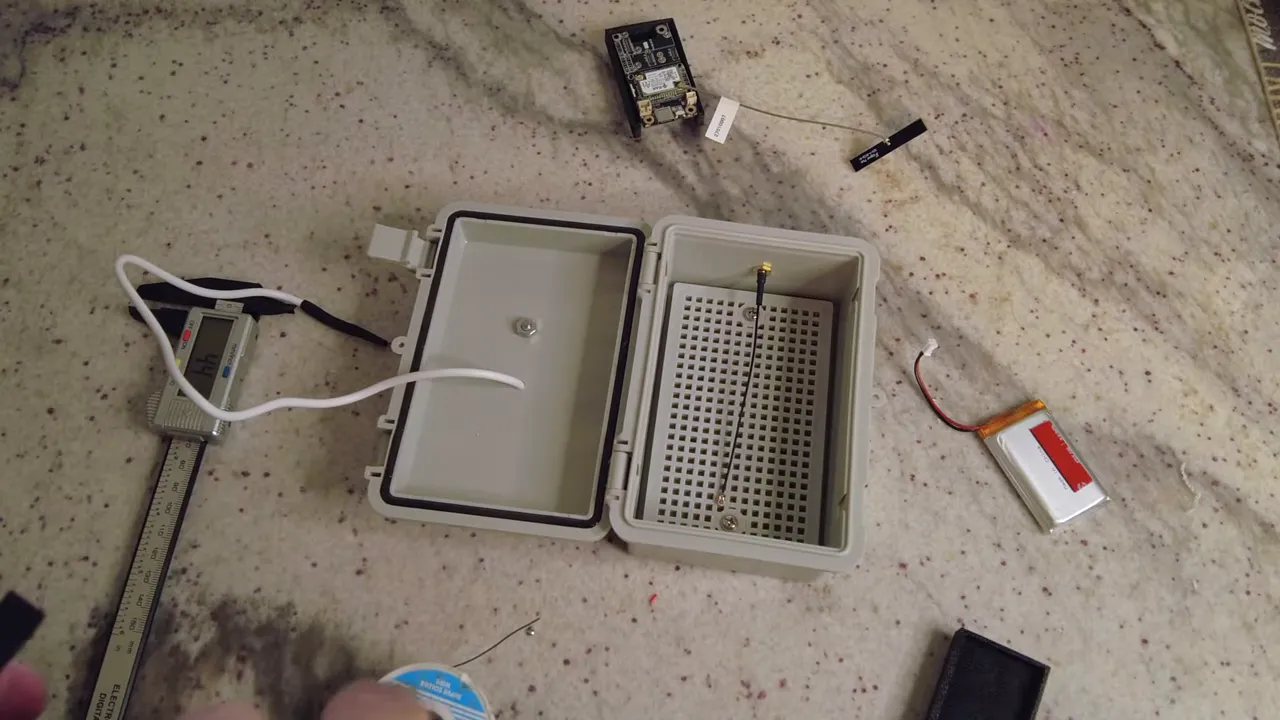 Open waterproof enclosure with internal pegboard, RAK board and a lithium battery laid out ready to be secured
