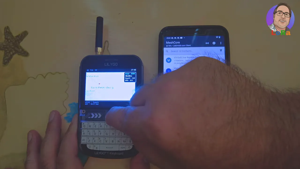 LilyGo T‑Deck clearly showing offline map tiles and a location label while a finger interacts with the map; a phone with MeshCore is visible to the right.