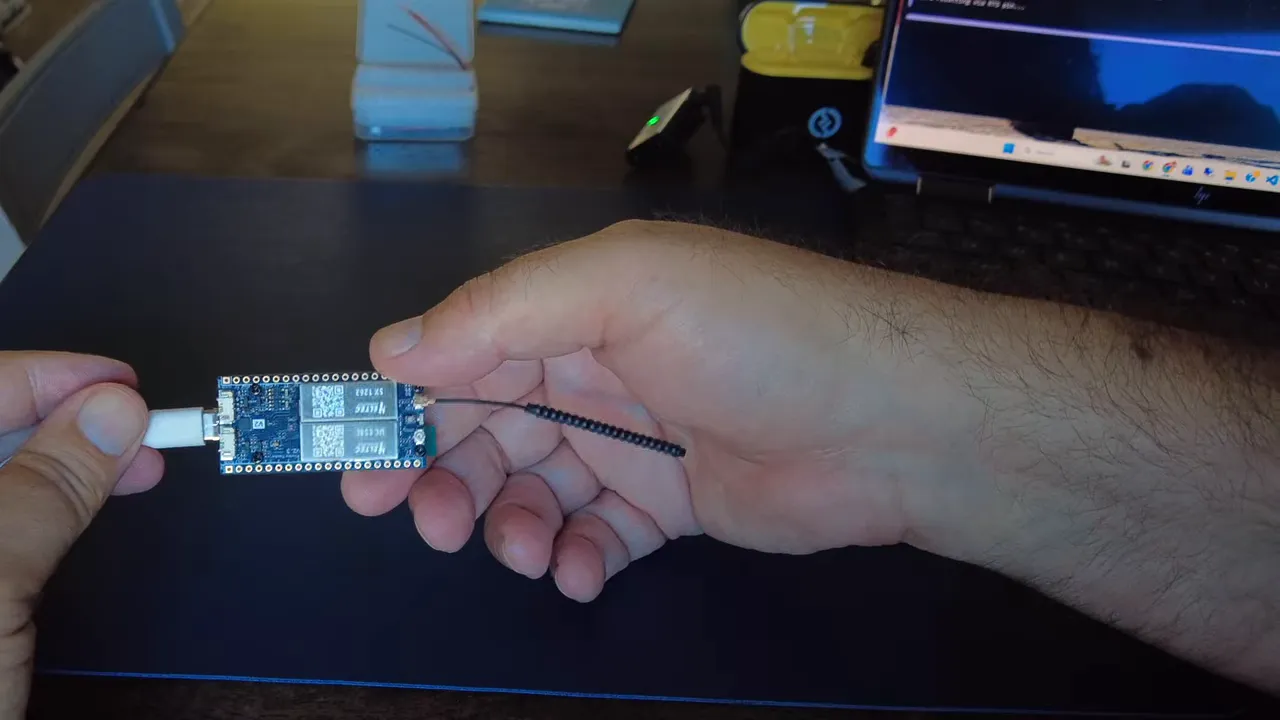Heltec Wireless Tracker V2 connected module held in hand with visible wiring for testing