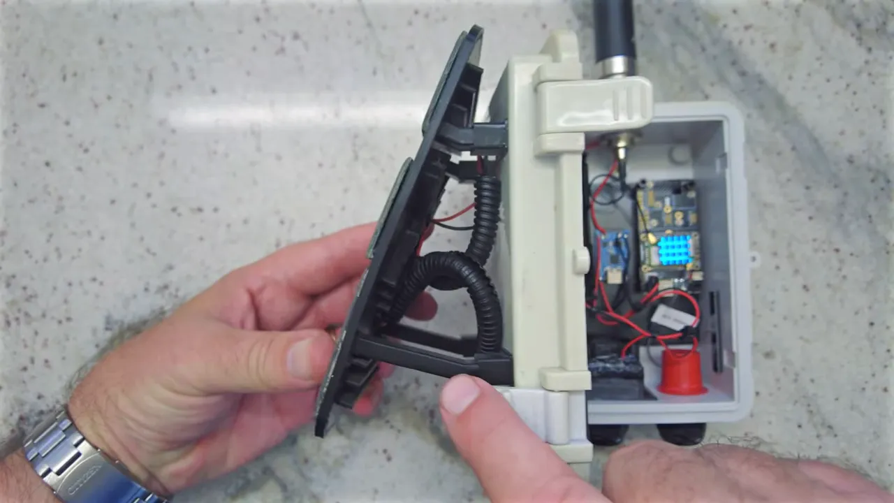 Small solar panel mounted on standoffs off an electronics enclosure showing the air gap and internal components