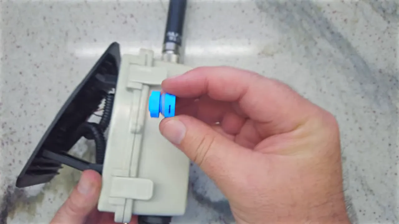 Blue breather plug held beside outdoor electronics enclosure showing installation location
