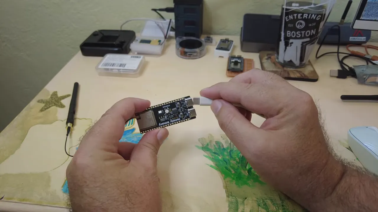 ESP32-S3 module held with hands while connected to the setup wiring