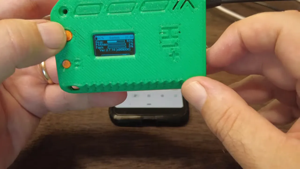 Close-up view of Heltec V4 OLED display showing PSRAM and heap percentage bars with hands holding the device