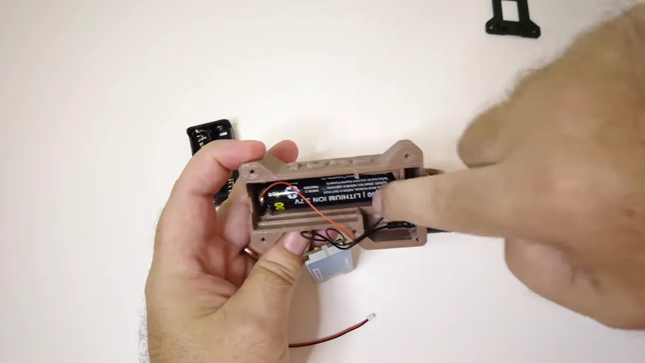Open Heltec T096 case showing the internal 18650 battery and wiring behind the board
