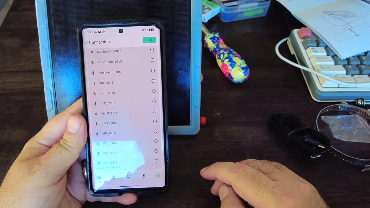 Clear view of the Meshtastic app on a phone showing multiple discovered nodes and a selected device badge