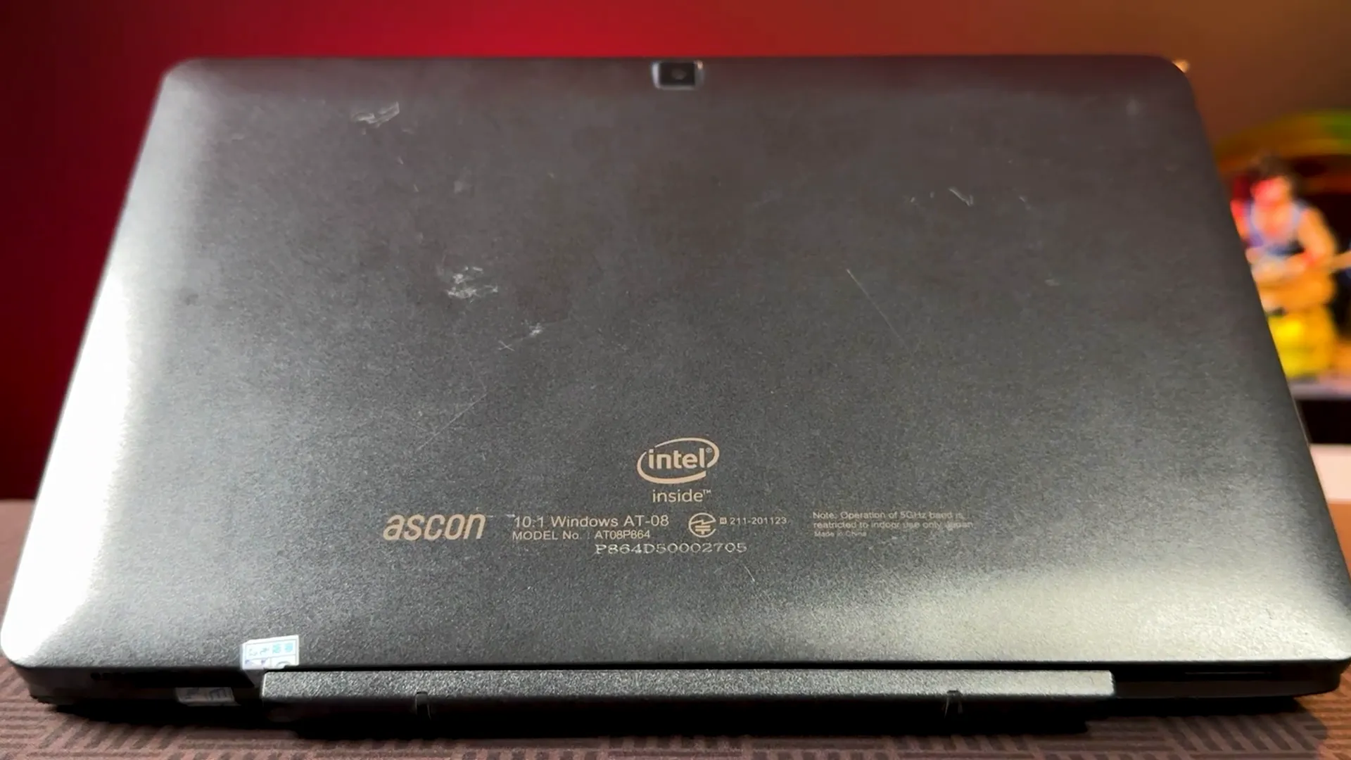 Detail bodi laptop memperlihatkan goresan dan tulisan merek