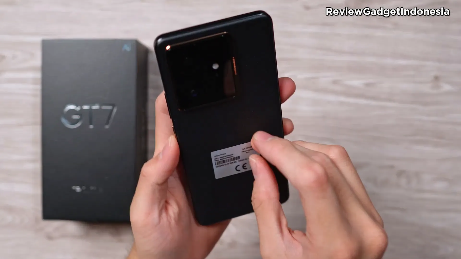 Realme GT7 varian warna hitam dengan frame coklat keemasan